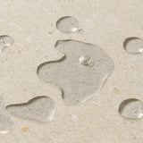 Close up of clear liquid on a beige background