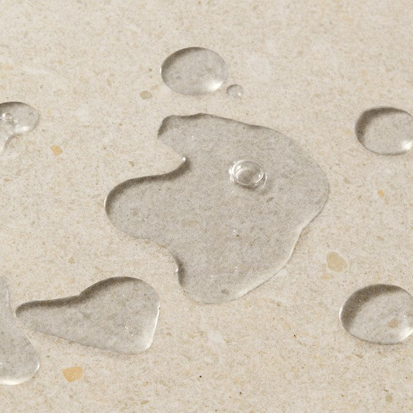 Close up of clear liquid on a beige background
