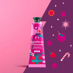 Pink hand balm tube labeled 'Sugarplum Passion' on a pink and purple background with decorative elements.