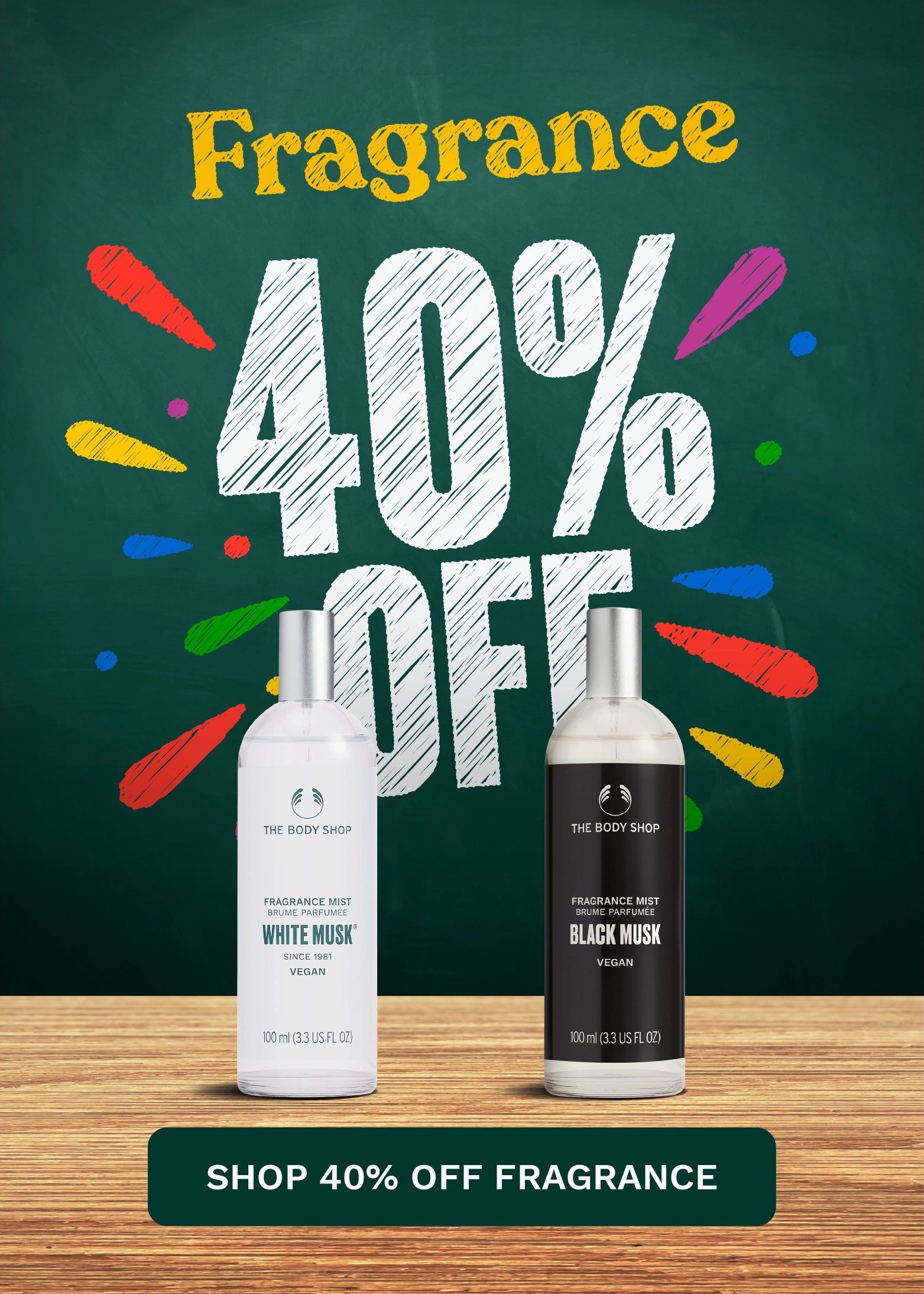Promotional advertisement for The Body Shop fragrance products showing two bottles on a wooden surface against a dark green chalkboard-style background with large text reading 'Fragrance 40% OFF' and a banner at the bottom that says 'SHOP 40% OFF FRAGRANCE'.