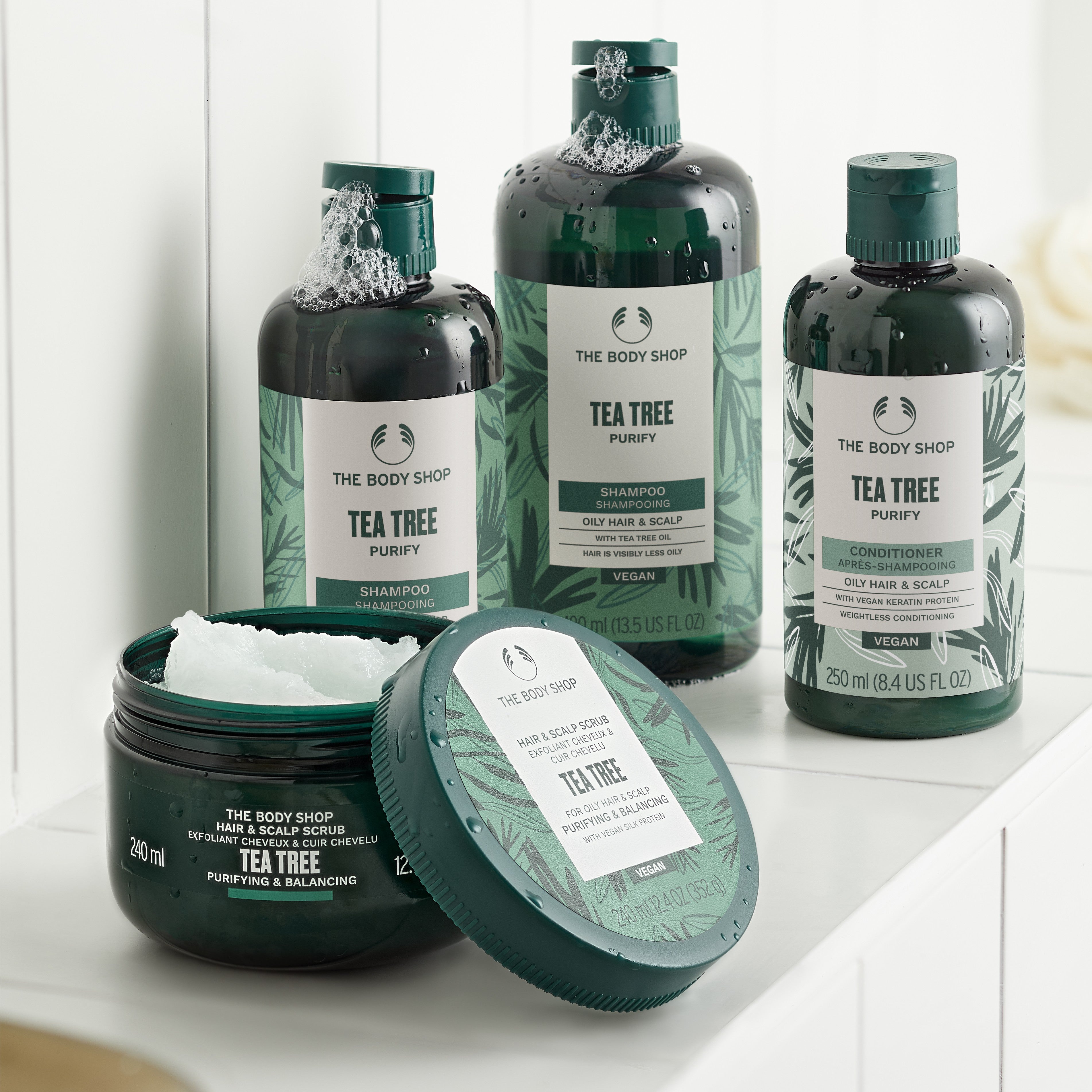 The Body Shop Tea Tree hair care products on a white surface