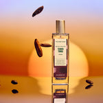 Bottle of 'The Body Shop' Tender Touch perfume with scattered almonds on a gradient background
