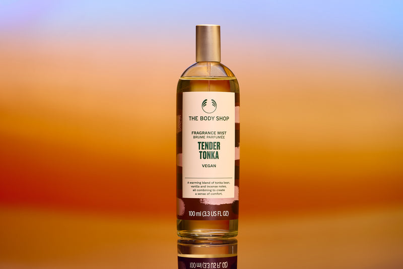 Bottle of The Body Shop Tender Tonka fragrance mist on a gradient background