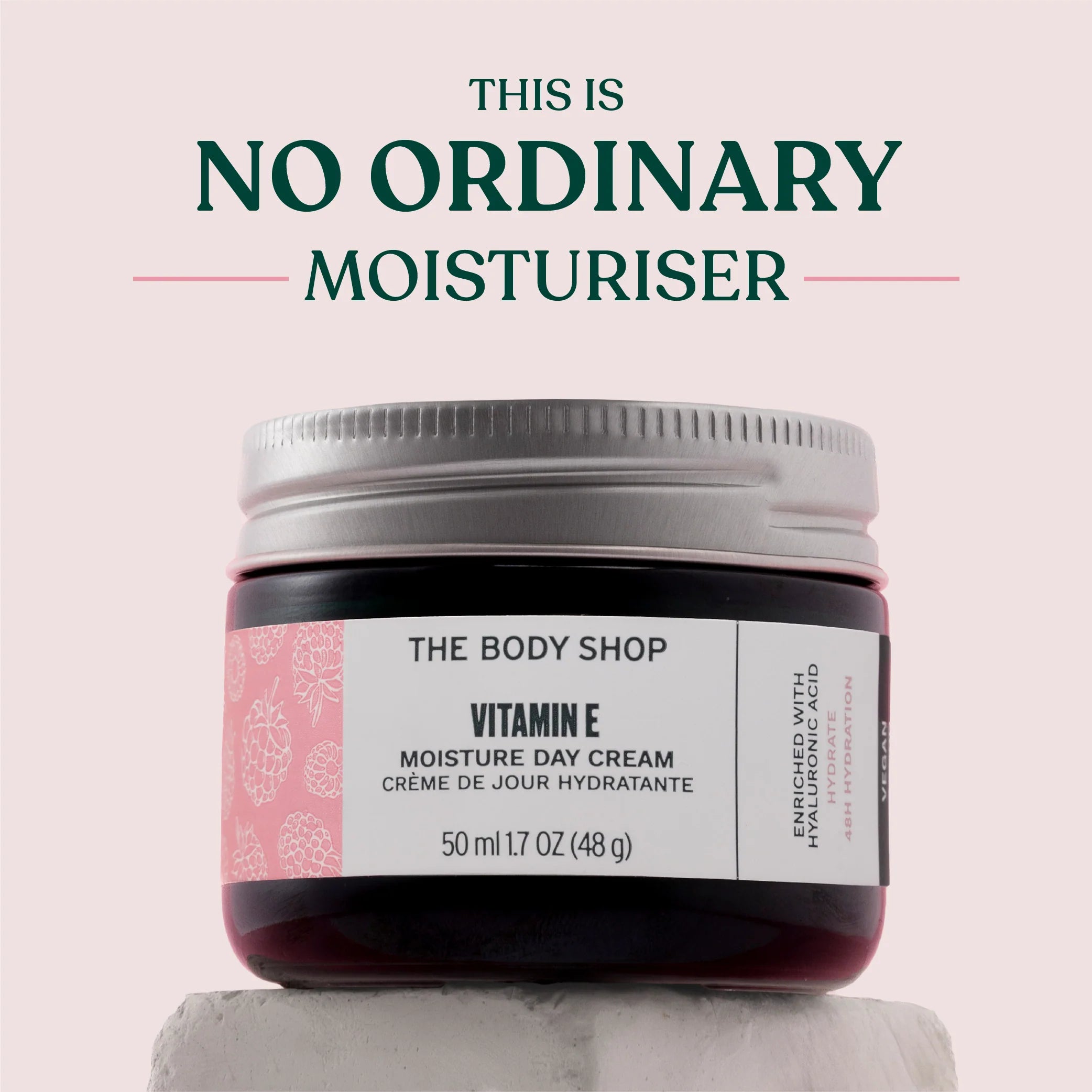 Jar of The Body Shop Vitamin E Moisture Day Cream on a light pink background with text 'This is No Ordinary Moisturiser'.