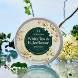 Body butter container with white tea and elderflower design on a natural background