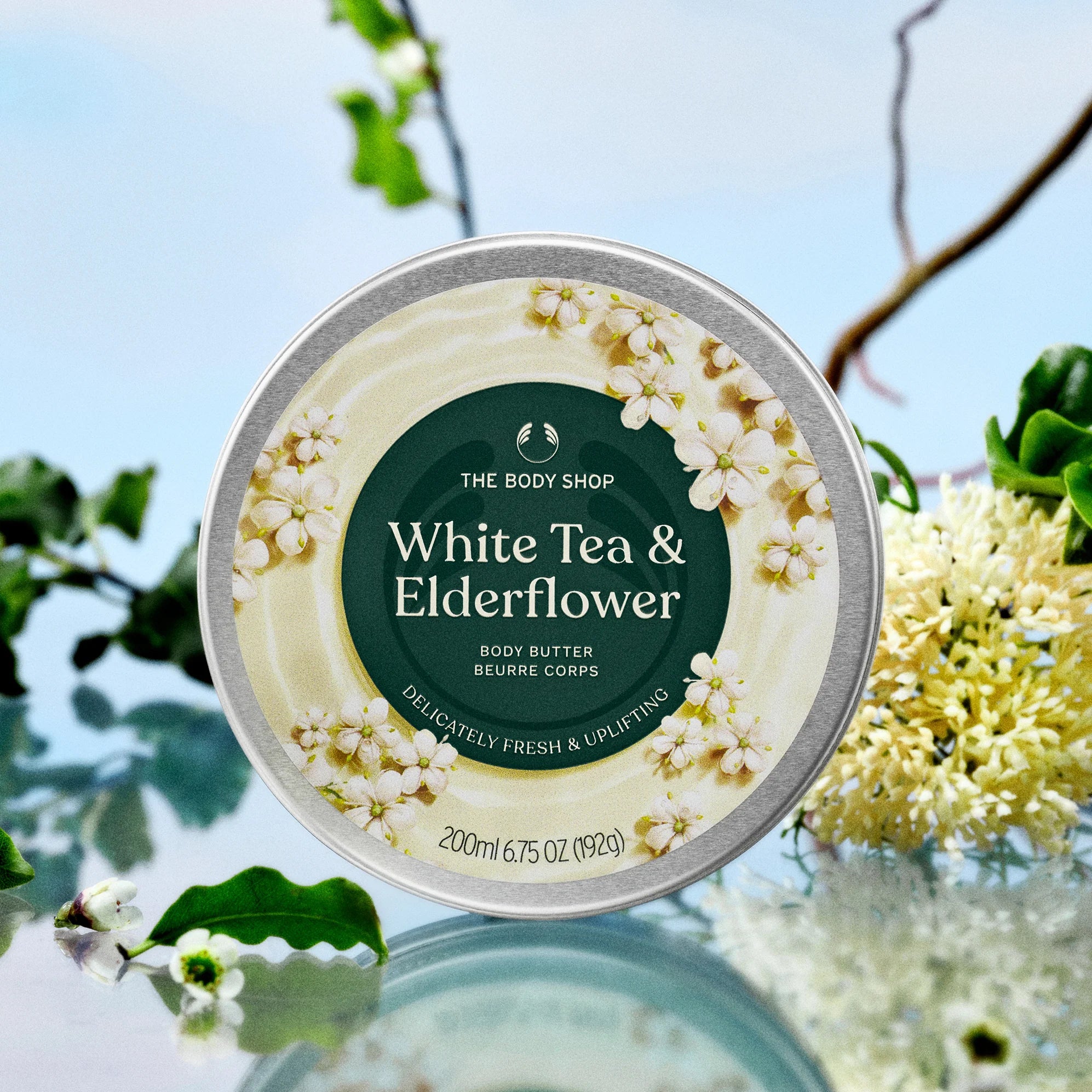 Body butter container with white tea and elderflower design on a natural background