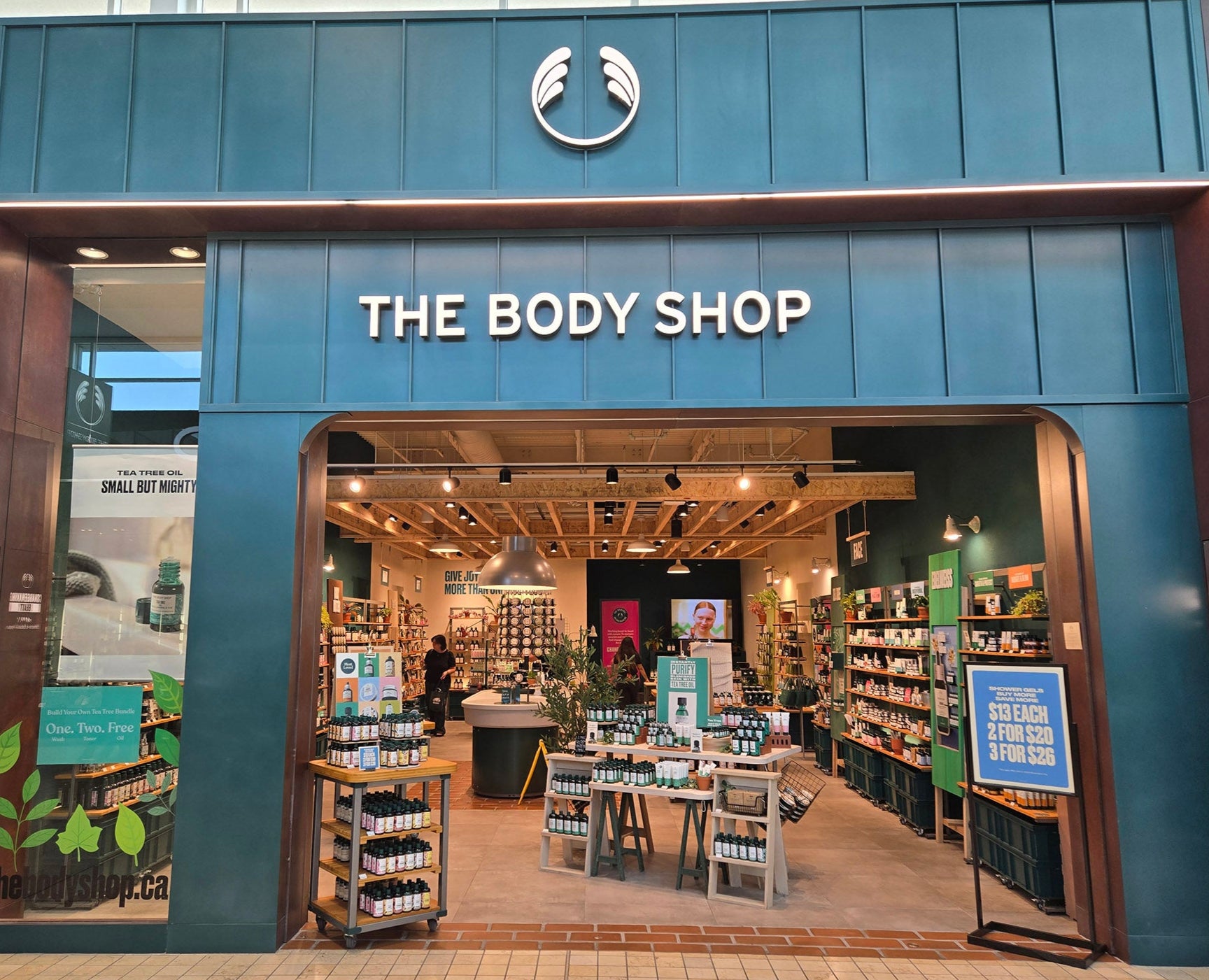 The Body Shop store entrance with branding and interior view.