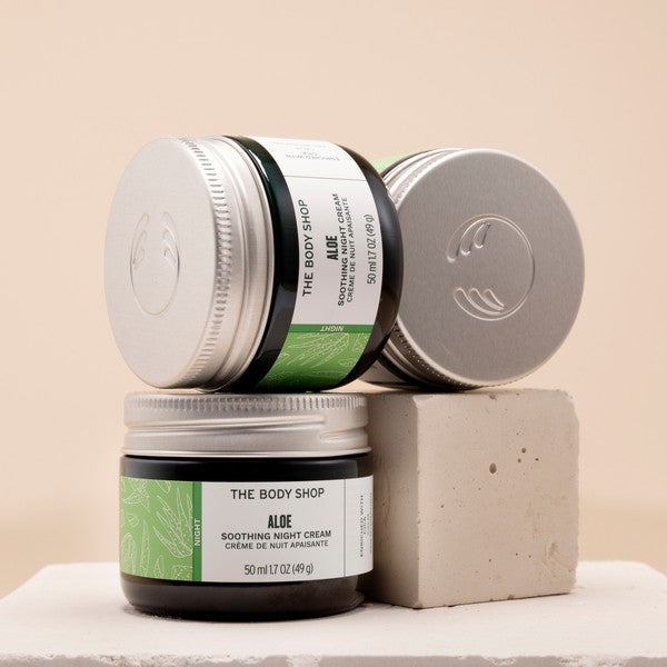 Three jars of The Body Shop Aloe Soothing Night Cream on a beige background