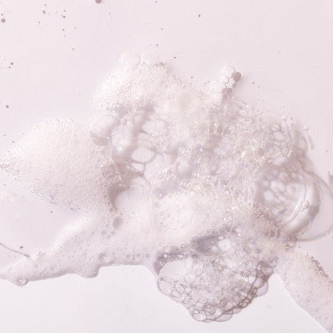 Close-up of white bubbles on a light pink background