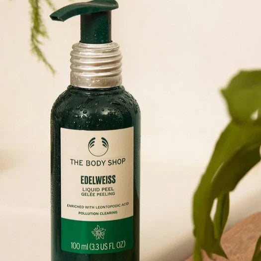The Body Shop Edelweiss Liquid Peel bottle with a plant in the background