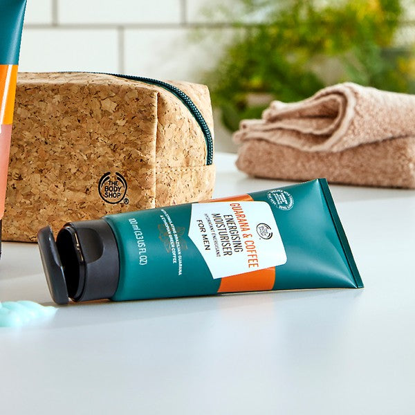 Packaged moisturizer with a cork bag and towel in the background
