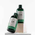 Two bottles of The Body Shop Tea Tree toner on a white background