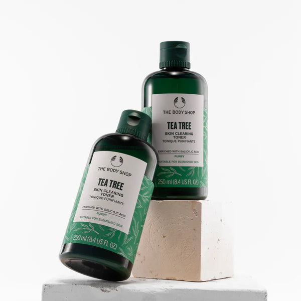 Two bottles of The Body Shop Tea Tree toner on a white background