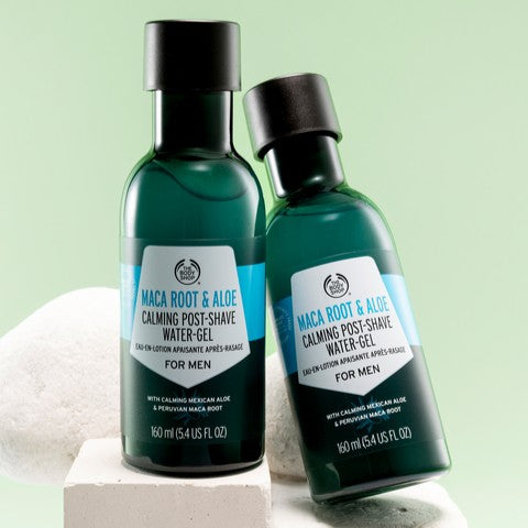 2 bottles of the body shop maca root and aloe post shave on a light green background