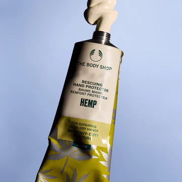 Tube of The Body Shop Hemp Hand Protector on a light blue background