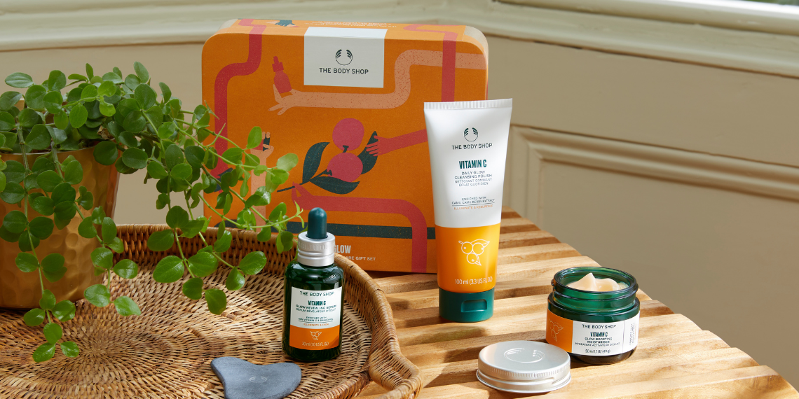 Collection of skincare products on a wooden surface with a decorative box in the background.