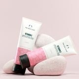 Two bottles of The Body Shop Vitamin E products on a light pink background