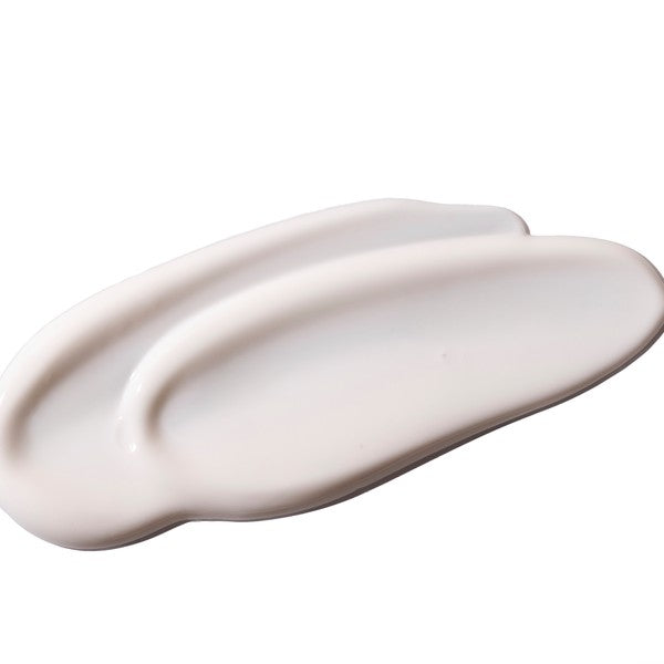 Swatch of a white coloured cream on a white background